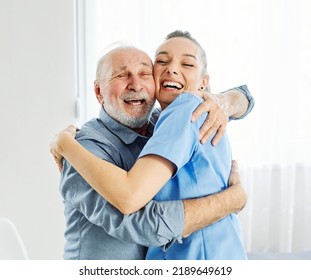 Doctor Or Nurse Caregiver Dancing And Senior Man Hugging At Home Or Nursing Home