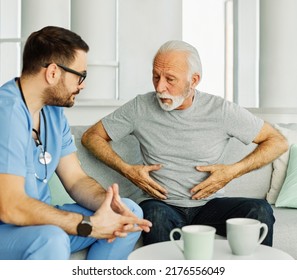 Doctor Or Nurse Caregiver Help Senior Man In Pain At Home Or Nursing Home