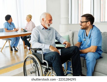 Doctor or nurse caregiver helping  senior man with chronic health condition  in a wheelchair at home or nursing home - Powered by Shutterstock