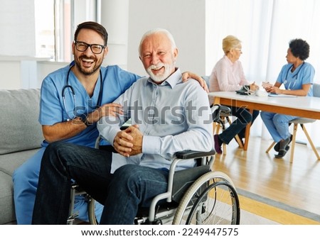 Doctor or nurse caregiver helping  senior man in a wheelchair at home or nursing home man who is paralyzed and with chronic health condition person