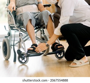 Doctor or nurse caregiver with senior man in a wheelchair wearing protective masks at home or nursing home - Shutterstock ID 2067554888