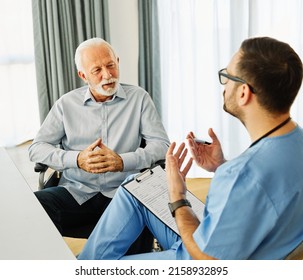 Doctor Or Nurse Caregiver With Senior Man In A Wheelchair  Holding  A Document Paperwork At Home Or Nursing Home