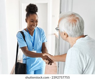 Doctor or nurse caregiver with senior man at home or nursing home, a caregiver standing on the front door arriving and being welcomed by a senior woman - Powered by Shutterstock