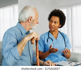 Doctor or nurse caregiver showing a prescrption drug to senior man at home or nursing home - Powered by Shutterstock