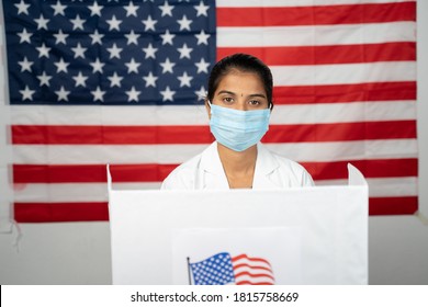 Doctor Or Nurse Coming To Polling Booth With Medical Mask Wearing For Voting - Concept Of US Election, In Person Voting Showing With US Flag As Background