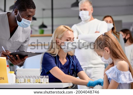 Doctor nurse give an injection vaccine against covid-19 to child teen girl. Mass vaccination of population will help stop spread of coronavirus in the world. Herd immunity. side view. copy space