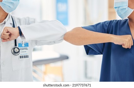 Doctor And Nurse Greeting With Elbow To Stop Covid Spread In A Hospital While Collaboration, Thank You Or Welcome. Healthcare Teamwork, Support And Support In A Medical Facility With Mask For Safety