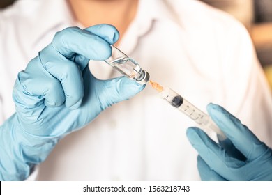 Doctor or nurse hand in blue gloves holding flu, measles vaccine injection with syringe prepare for baby vaccination, medicine and drug concept. - Shutterstock ID 1563218743