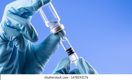 Doctor or nurse hand holding flu vaccine shot, measles injection syringe for baby and adult vaccination, medicine and drug concept
