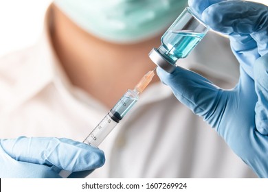 Doctor or nurse hand with nitrile glove holding flu, measles vaccine shot for baby vaccination, medicine and drug concept - Shutterstock ID 1607269924