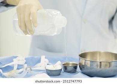 Doctor or nurse hand with surgical set and medical equipment on blue surgical tray inside operating room.Sterile surgical instrument tool equipment for surgery.Infection control. - Powered by Shutterstock