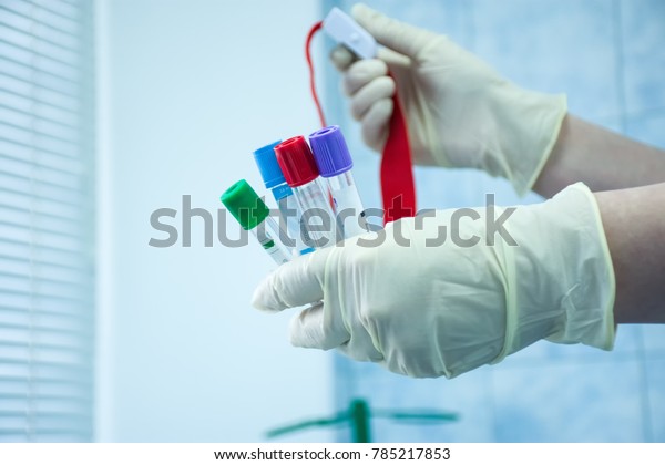Doctor or\
nurse holding in hand test tubes for blood tests, taking other\
biological samples for diagnostic tests and diagnosis of disease on\
background of procedural room or\
laboratory