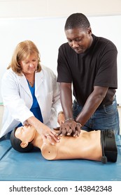 Doctor or nurse instructs an adult student in CPR life-saving techniques.