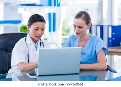 Doctor and nurse looking at laptop in medical office