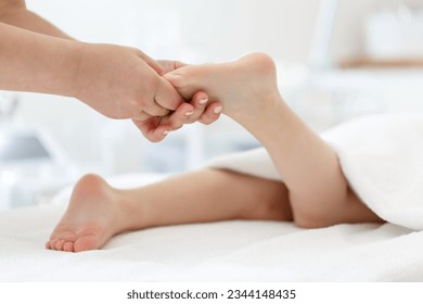 Doctor or a nurse massages the legs of a small child with her hands. Close-up of baby's foot - Powered by Shutterstock