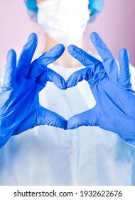 Doctor Or Nurse In Medical Mask And Hands In Protective Gloves Shows The Symbol Of The Heart. Love, Care And Safety Symbol. Doctor Care And Love Concept To Patients. Close-up.