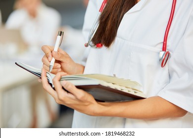 Doctor or nurse notes appointments in a calendar or waiting list