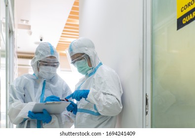 doctor and nurse in personal protective equipment or ppe including white suit, mask, face shield and gloves are discussing about treatment of pateint with coronavirus. covid-19, quarantine concept