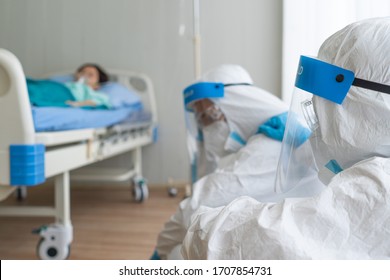 doctor and nurse in personal protective equipment or ppe feeling sad after sick patient with covid-19 or coronavirus infection was dead in hospital during pandemic. medical concept - Shutterstock ID 1707854731