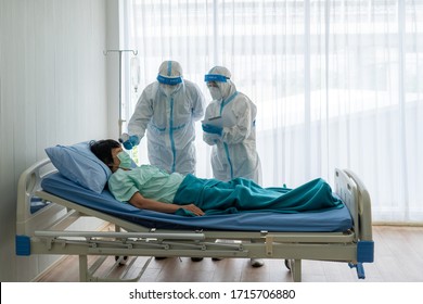 Doctor And Nurse In Personal Protective Equipment Or Ppe Treating The Senior Asian Woman Patient With Covid-19 Or Coronavirus Infection In The Isolation Unit In The Hospital During Pandemic