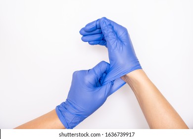 Врач или медсестра надевают синие нитриловые хирургические перчатки, профессиональную медицинскую безопасность и гигиену для хирургии и медицинского осмотра на белом фоне.