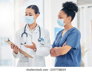 Doctor And Nurse Reading Medical Information Paperwork With Mask For Safety From Covid Or Corona Virus In A Hospital. Healthcare Workers Discuss And Analyze Pandemic Data Report In A Clinic Together