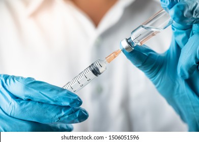 Doctor, nurse, scientist, researcher hand in blue gloves holding flu, measles, coronavirus, covid-19 vaccine disease preparing for human clinical trials vaccination shot, medicine and drug concept. - Shutterstock ID 1506051596