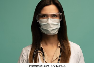 Doctor / Nurse Smiling Behind Surgeon Mask. Closeup Portrait Of Young Caucasian Woman Model In White Medical Scrub.