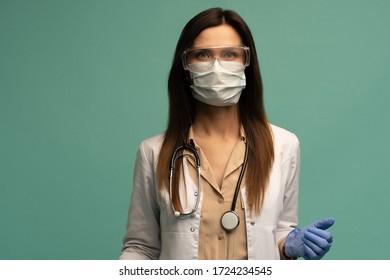 Doctor / Nurse Smiling Behind Surgeon Mask. Closeup Portrait Of Young Caucasian Woman Model In White Medical Scrub.