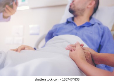 Doctor And Nurse Talk With Husband Patient About Examining Result From Doctor, Family Health Care, Palliative Care, With Wife Holding Hand Of Patient At Hospital. Selected Focus