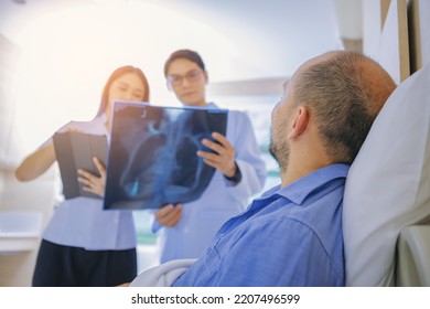 Doctor And Nurse Talk With Husband Patient About Examining Result From Doctor, Family Health Care, Palliative Care At Hospital. Selected Focus