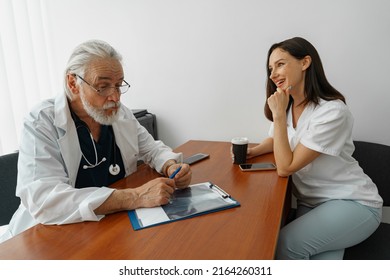 Doctor And Nurse Talking During A Break In The Medical Office In Clinic