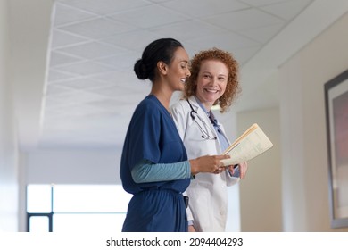 Doctor And Nurse Talking In Hospital Hallway