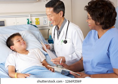 Doctor And Nurse Visiting Child Patient On Ward