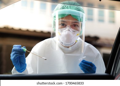 Doctor or nurse wearing PPE, N95 mask, face shield  and personal protective gown standing beside the car/road screening for Covid-19 virus 