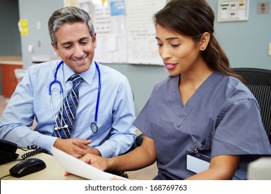 Doctor With Nurse Working At Nurses Station