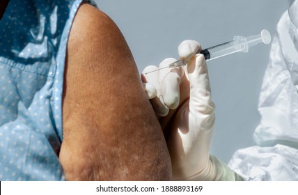 Doctor Or Nurses Wearing Ppe Suit, Mask, Face Shield And Medical Gloves Are COVID-19 Vaccine Injection To Old Woman Upper Arm For Immunization, Breakthrough And Against Coronavirus 2019 Or COVID-19. 