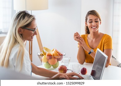 Doctor Nutritionist, Dietician And Female Patient On Consultation In The Office. Young Smiling Female Nutritionist In The Consultation Room. Nutritionist Desk With Healthy Fruit And Measuring Tape.