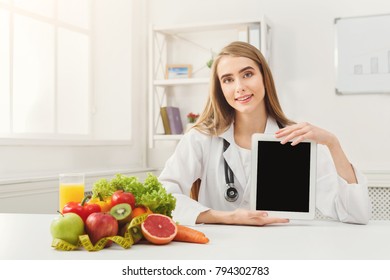 Doctor Nutritionist With Fruits And Holding Blank Digital Tablet, Healthy Eating And Slimming Concept. Mockup For Right Nutrition Menu, Copy Space