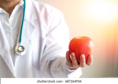 Doctor Or Nutritionist Hold An Apple. Good Medical Healthcare Nutrition Concept. An Apple A Day Keeps The Doctor Away