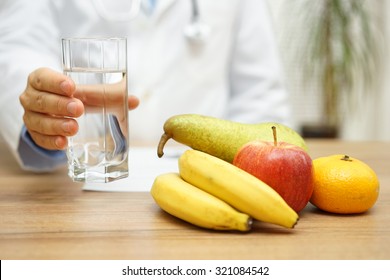 Doctor Is Offering Water And Fruit After Reading Diagnose. Healthy Life And Health Care Concept
