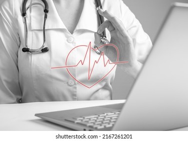 Doctor With Ok Gesture Reporting Electrocardiogram Results To Patient Online Using Laptop. Remote Medical Consultation Concept. Woman In Lab Coat Sitting At Table With Computer. Photo