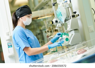 Doctor Operating Equipment Near Newborn Baby In Incubator At Neonatal Resuscitation Center