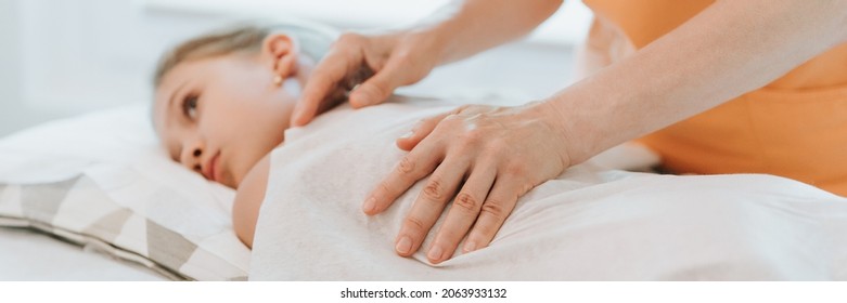 doctor osteopath hands does physiological and emotional therapy for eight year old kid girl. pediatric osteopathy treatment session. alternative medicine. taking care of the child's health. banner