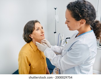 Doctor palpates of mature woman's neck for diagnostics of thyroid diseases and hypothyroidism at medical clinic. Thyroid treatment - Shutterstock ID 2000029754