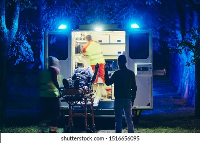 Doctor and paramedic of emergency medical service take care of old ill man. Team of emergency medical service rescuing old patient. Concepts health care, rescue and goodbye.