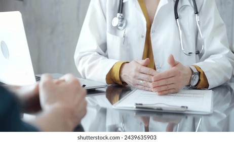 Doctor and patient consultation with clipboard and medication notes. Close-up view of unknown female doctor using a tablet during a patient consultation - Powered by Shutterstock