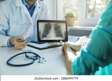 Doctor And Patient Discuss Chest X-ray Results On Digital Tablet In Clinics Office