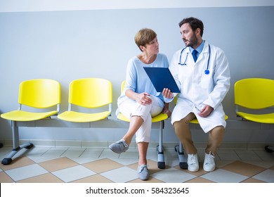 Doctor and patient discussing over report in hospital waiting room