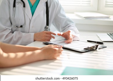 Arzt und Patient diskutieren etwas, nur Hände am Tisch